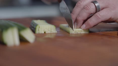 close-up shot of a chef slicing cucumbers into tiny squares, showcasing precision and technique. perfect for cooking tutorials, food preparation, and culinary presentations.