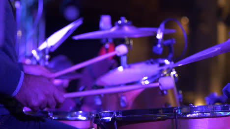 drummer playing at concert wearing suit, close up hands view