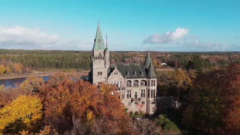 tracking shot towards teleborg castle in växjo, sweden, fall, orange and yellow leafs