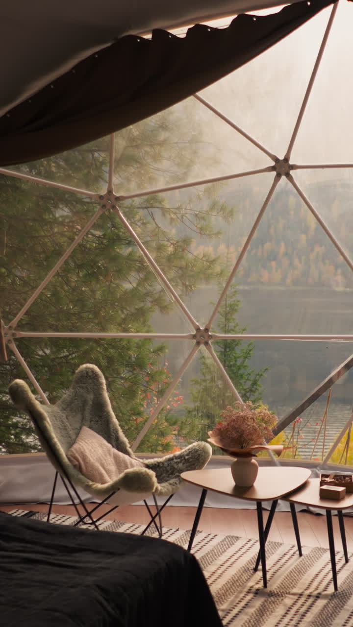 가을의 산 호수 전망을 가진 유리 테라스. 조용한 주말을 즐기기 위해 아한 가구로 장착 된 현대적인 숙박 시설. 관광객을위한 글램핑 하우스.