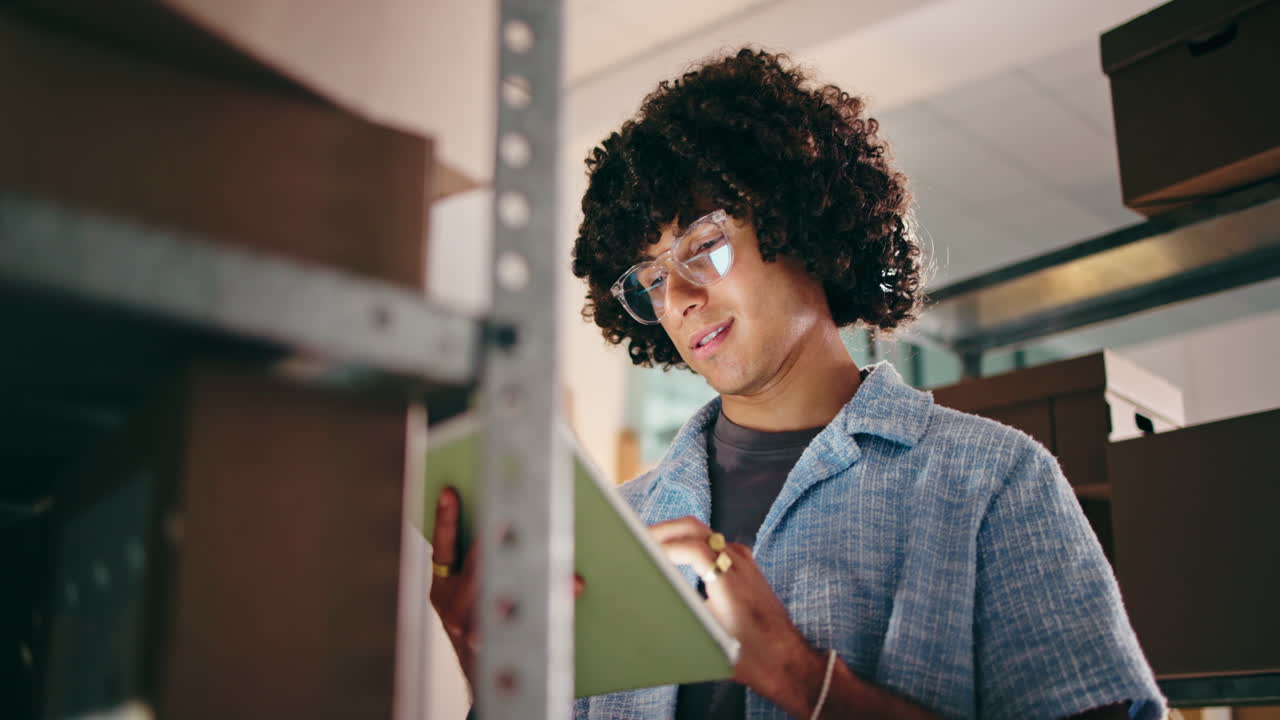 Young Man Checking Inventory on Tablet in Warehouse