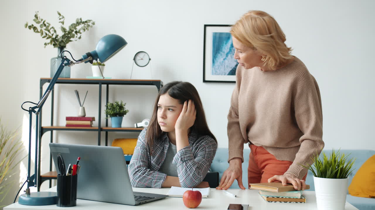 Madre che aiuta una figlia adolescente con i compiti online