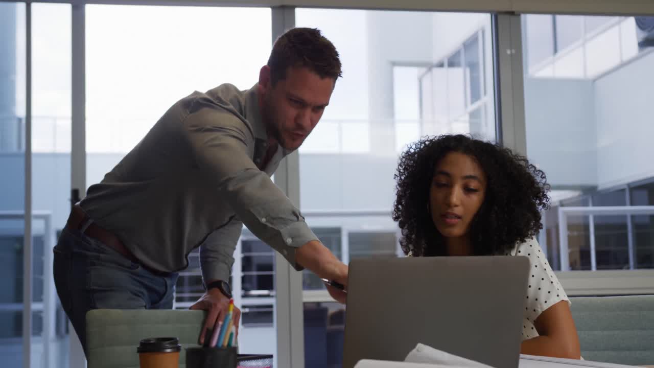 jovens executivos de escritório discutindo sobre laptop em um escritório moderno