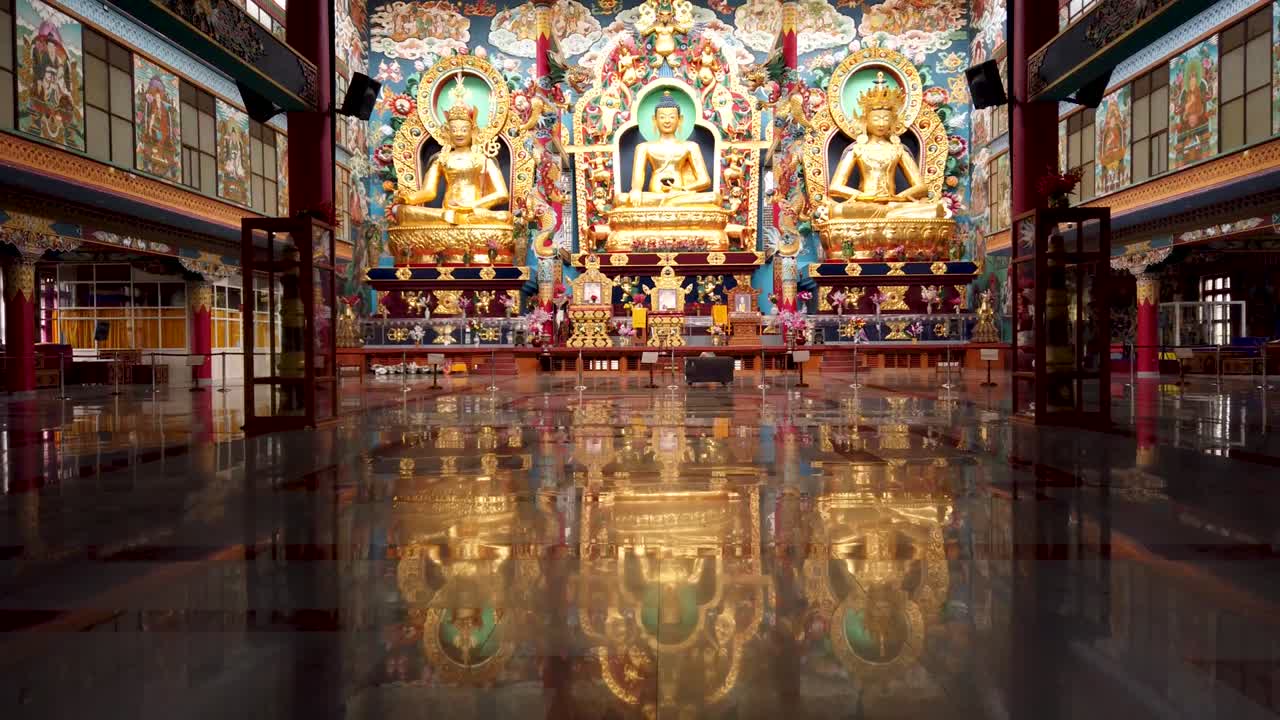 una escena dramática de los interiores de los monasterios tibetanos donde grandes estatuas de budas en diferentes formas decoradas con color dorado en la ciudad de bylakuppe en karnataka, india.