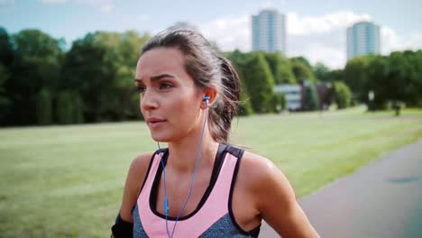 Young-woman-listening-to-music-and-warming-up-before-running,-Katowice,-Poland