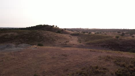 Flying-Over-Arid-Hills-Revealing-Pond-In-Alentejo,-Portugal