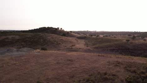 volando sobre colinas áridas que revelan un estanque en alentejo, portugal