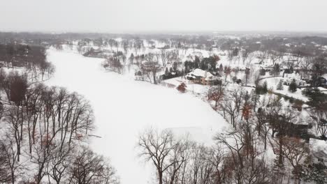 Aerial,-homemade-ice-skating-rink-on-a-frozen-backyard-pond-during-winter