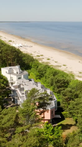 Vertical drone shot of upscale condos at a beach, sunny day at the Baltic sea