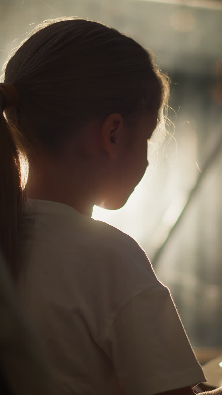 el niño bebe té contra la ventana soleada. la niña linda disfruta de una bebida dulce sentada en una acogedora tienda de glamping. el niño relajado pasa una mañana soleada en casa