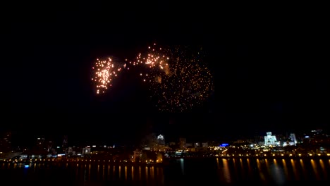 colorful fireworks display over a city by the river at night