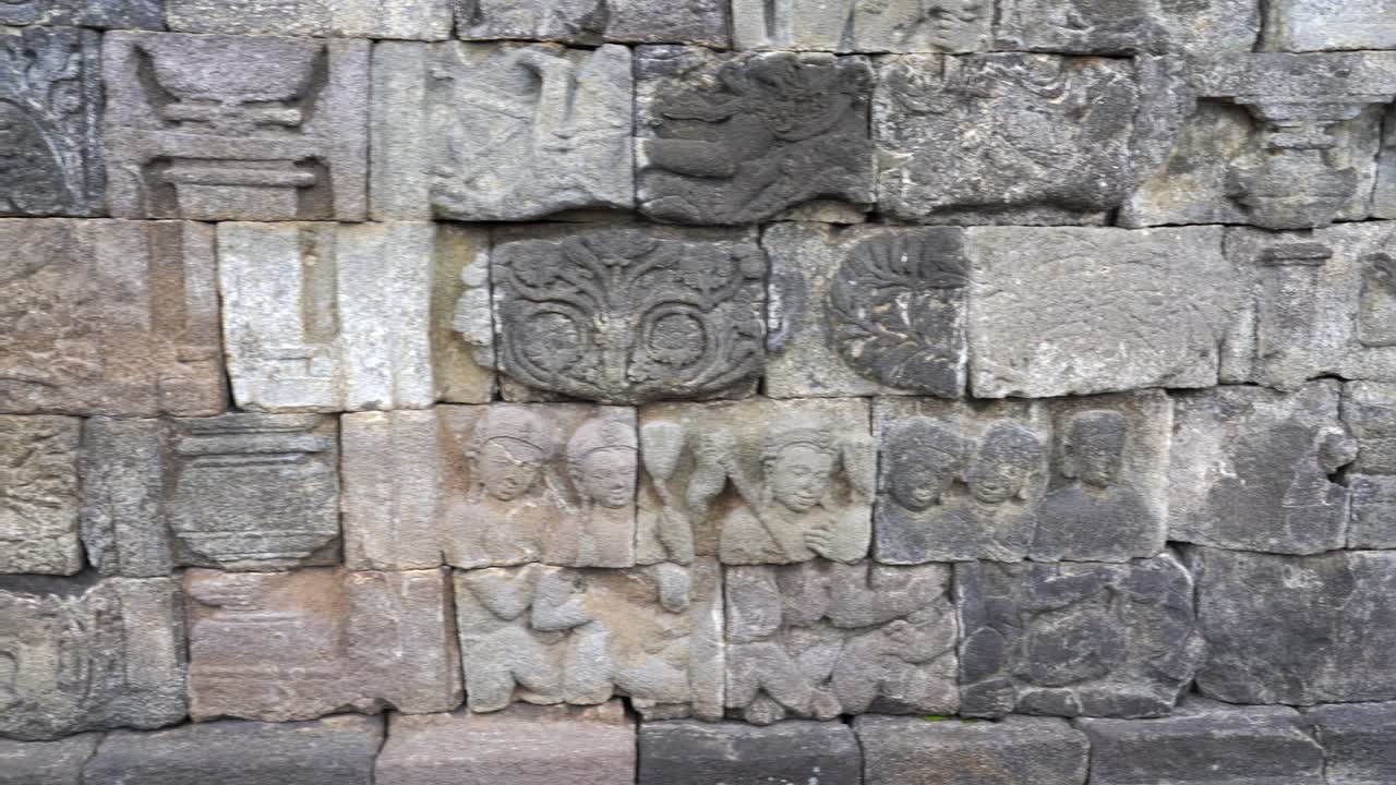 Indonesia,Jawa Island,Yogyakarta,Unesco world heritage Borobudur Temple's inside,wall reliefs, Camera slides slowly from left to right and shows the relief in details,relief ends at the walking path.