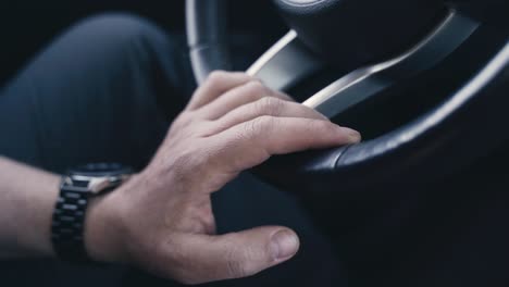 a man keeps his hand on the steering wheel of a car during a trip.