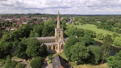 Aerial-view-low-orbiting-Holy-Trinity-church-and-river-Avon-Weir,-Stratford-Upon-Avon,-Warwickshire-historical-English-town