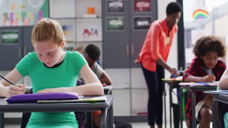 portrait of happy diverse schoolchildren at desks in school classroom