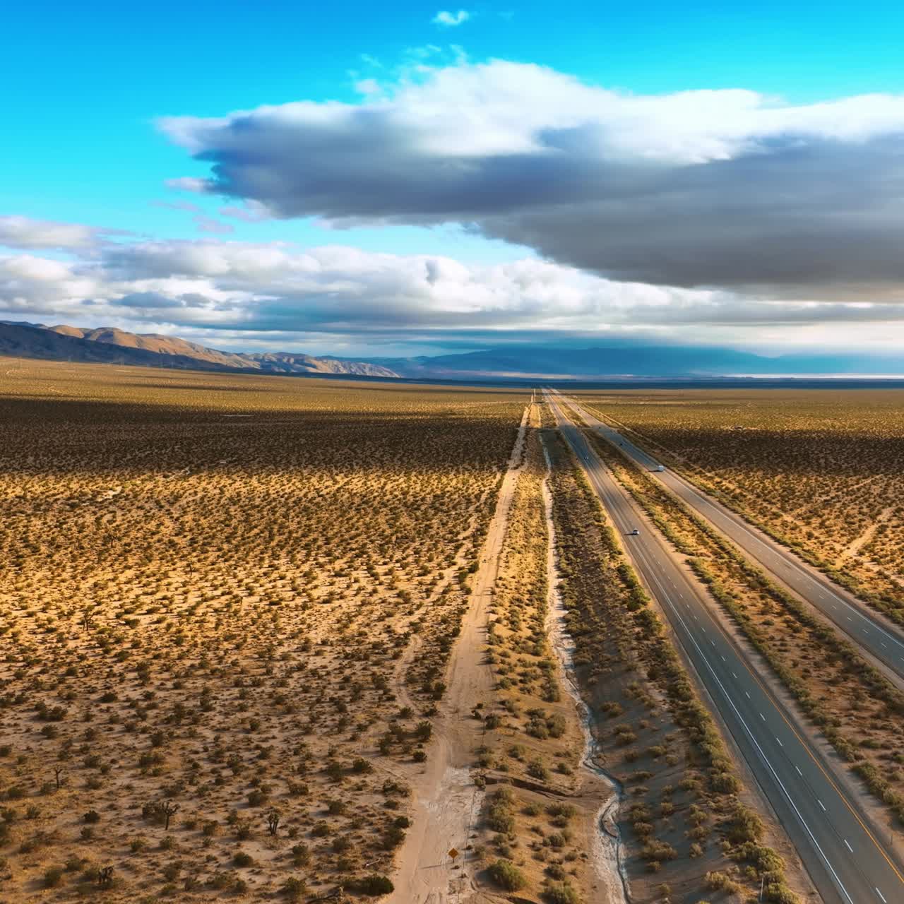 Amazing view of the desert crossed by the highways. Some cars move by the roads. Aerial perspective