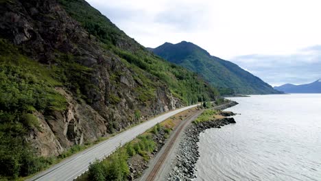 Alaskan-Ocean-coastline-with-green-tree-covered-mountains