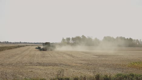 Agricultural-Tractor-Working-At-The-Field,-Creating-Dust-During-Harvest-Season