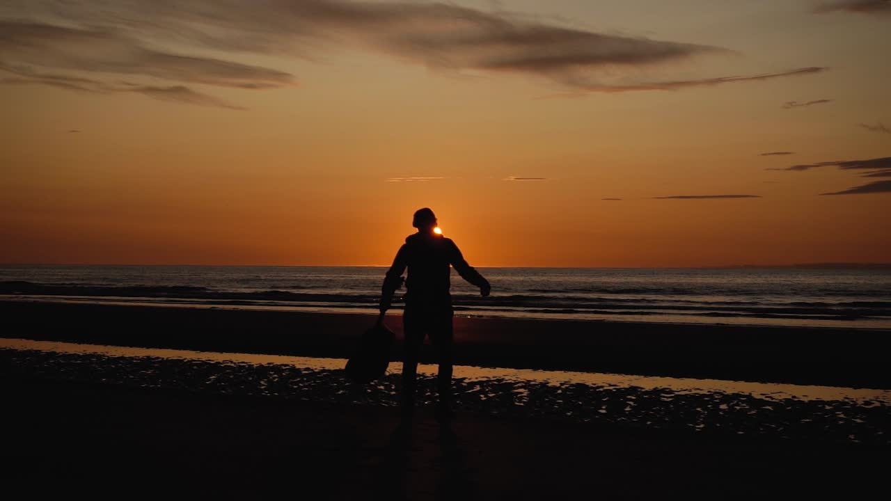 일몰-18에 뒷모래 해변에서 기타와 함께 달리는 남자