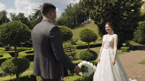 Lovely-newlyweds-caucasian-bride-and-groom-with-bouquet-in-park,-wedding-couple-first-meeting