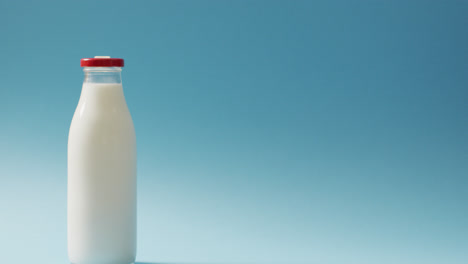 Video-of-glass-bottle-of-milk-on-blue-background