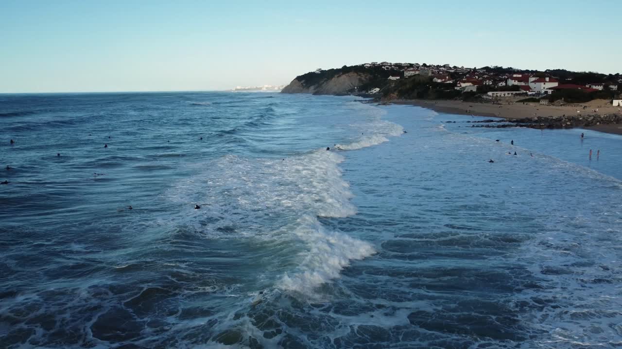 Coastal Beach View with Waves and Distant Town