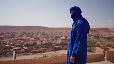 man in traditional moroccan clothing in the desert