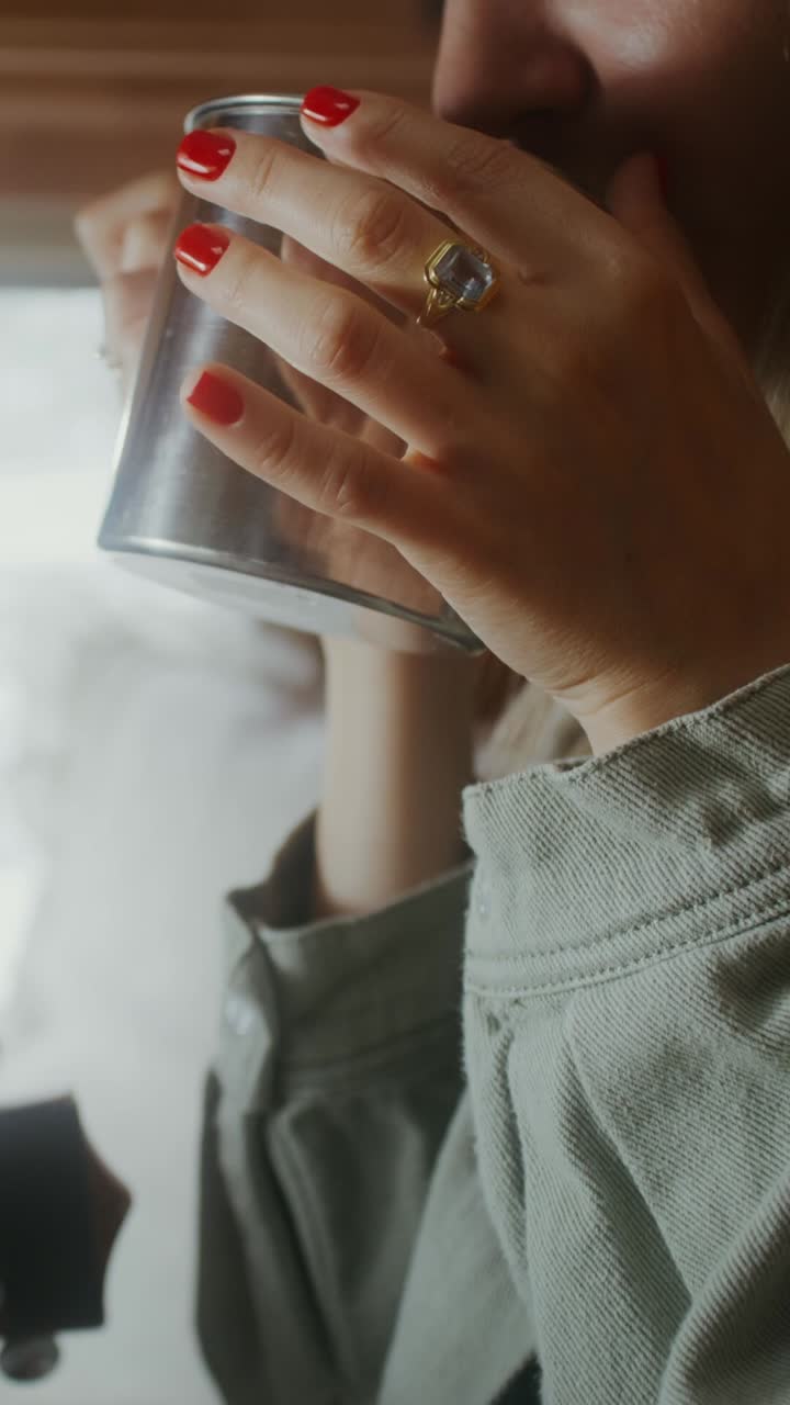 mujer bebiendo de una taza en una caravana