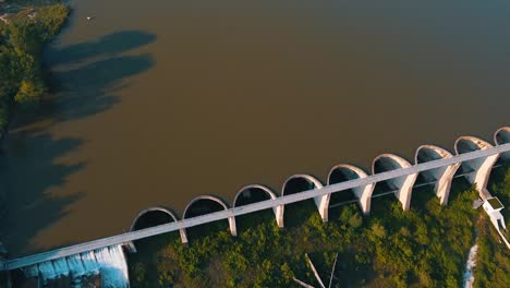 drone shot of a dirty lake blocked by a long dam