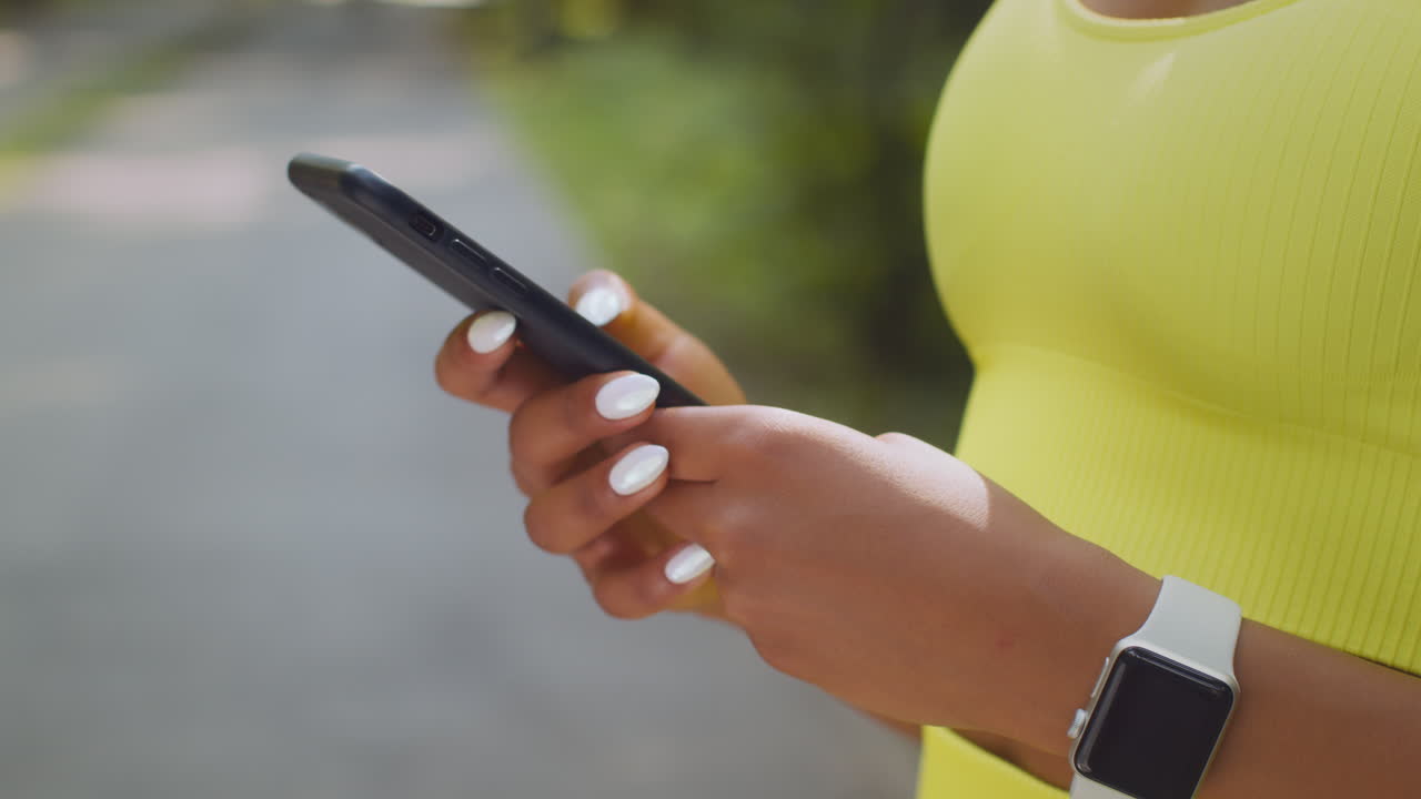 mujer usando el teléfono mientras hace ejercicio al aire libre