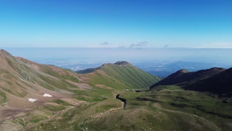 drone captures the vast tikov mountains near tikov lake with rolling green hills and clear skies