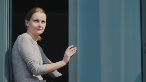 a woman peeks out of the window