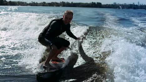 Sportsman-wake-surfing-on-waves-in-slow-motion.-Rider-making-wake-surf-stunt