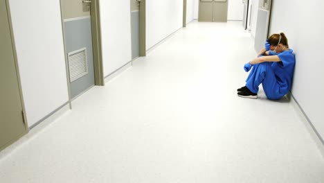 tensed female doctor sitting in corridor