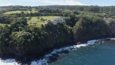 Drohnenaufnahme-Eines-Luxuriösen-Privaten-Resorts-An-Der-Seite-Einer-Klippe,-Umgeben-Von-üppigem-Grün