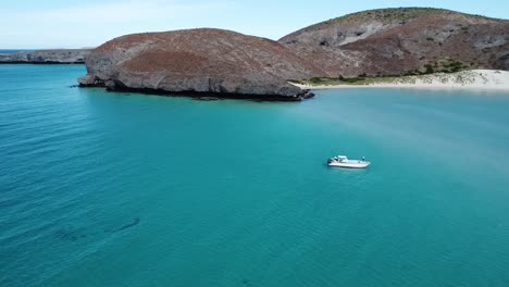 Aerial-view-of-Balandra-Beach-with-a-small-white-boat-in-the-crystal-clear-turquoise-waters,-Baja-California-Sur,-La-Paz,-Mexico