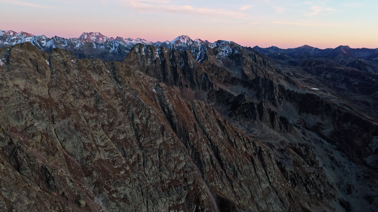 Aerial view of Colle della Lombarda at sunset, showing rugged mountain peaks