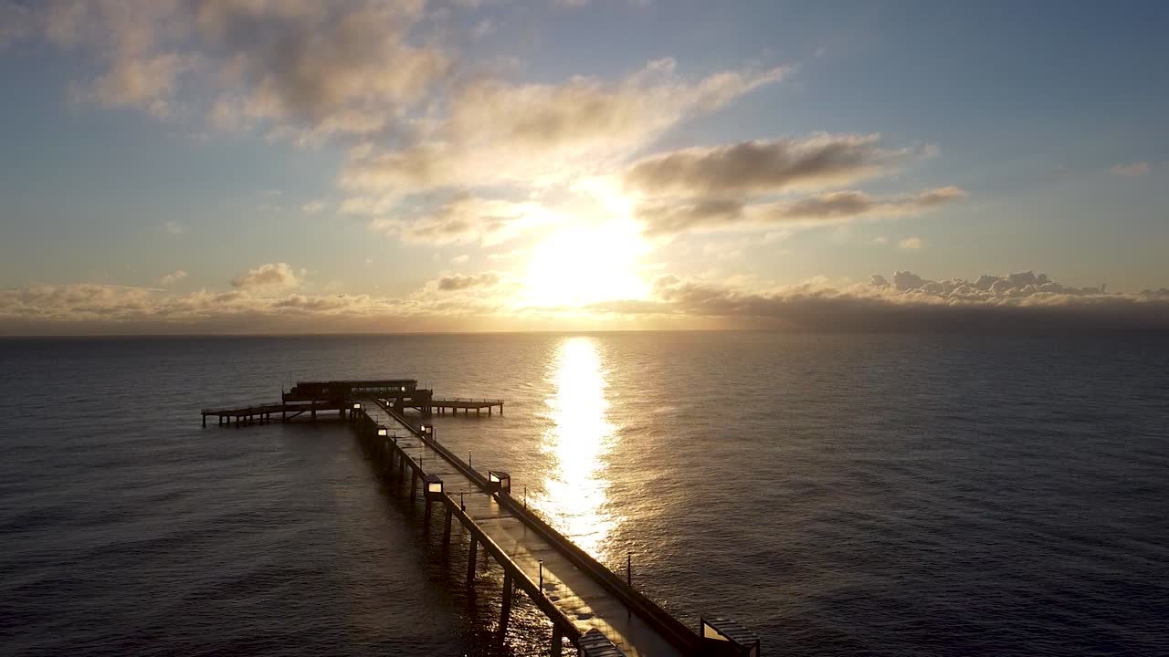 Rising aerial beautiful warm sunrise above Deal pier Kent coastal skyline