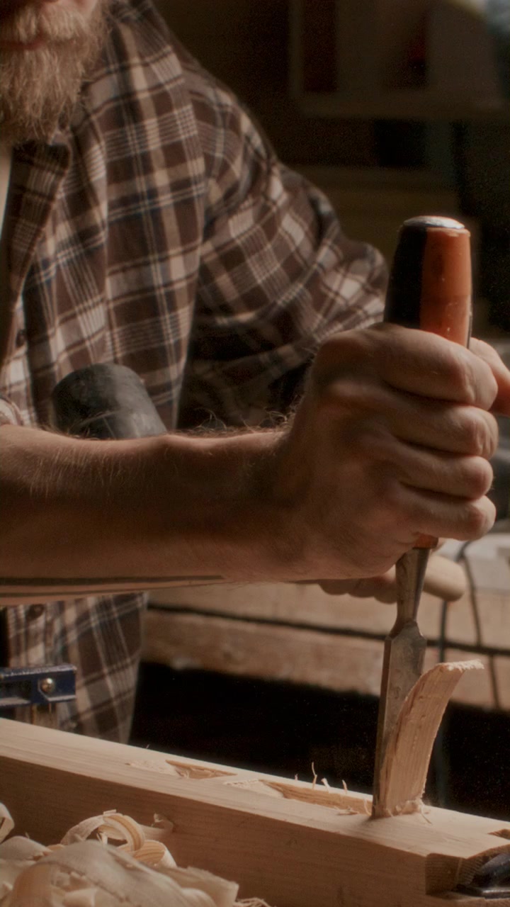 Close Up of Woodworker Carving Timber with Chisel and Mallet