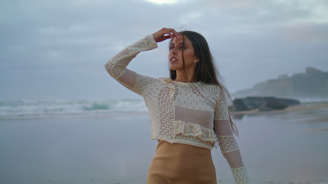 저녁 해변을 고 있는 만적인 여자. 휴가 중에 손을 들고 있는 긍정적 인 여인