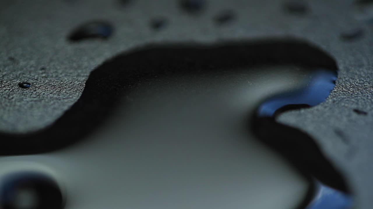 매크로 카메라를 닫을 때 슬로우 모션으로 물 방울 캡처 보드니 hladinu a pomalu se rozpustí do stran on dark backgound plate on light reflection