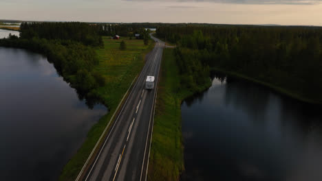 автомобиль проезжает по мосту посреди арктической сельской местности лапландии - взгляд с воздуха