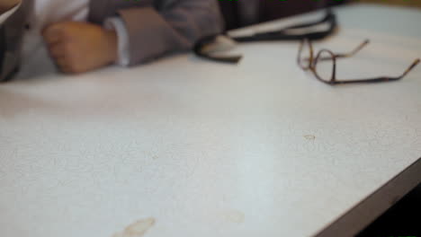 man rolls a pair of dice across a diner table