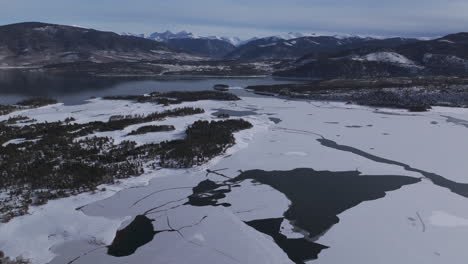 downtown frisco toward keystone colorado aerial cinematic drone lake dillon marina summit cove cloudy snowy winter morning view silverthorne ten mile range breckenridge calm unfrozen ice forward