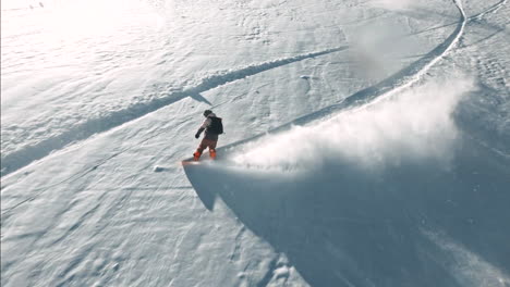 fpv male snowboarder riding down fresh powder snow followed blue sky steep turns sunset at vail pass colorado