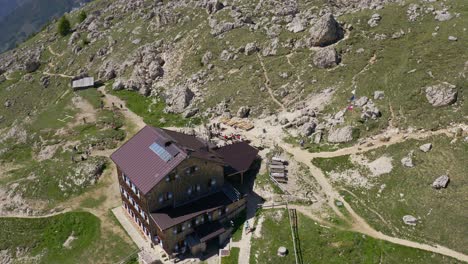 aerial view showing mountain hut at roda di vael during sunny day with hiking people