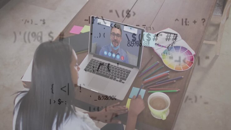 Multiple changing symbols against woman having a video call with male colleague on laptop at office