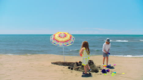 children building a sandcastle on the beach