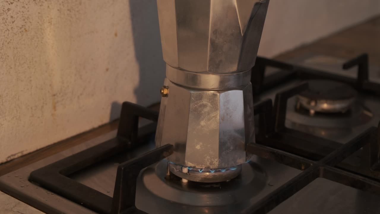 Accensione al rallentatore: moka che si riscalda sul fornello della cucina
