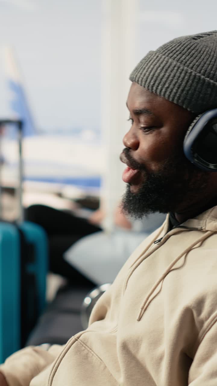 Vertical Video African american man on video conference call using airport internet